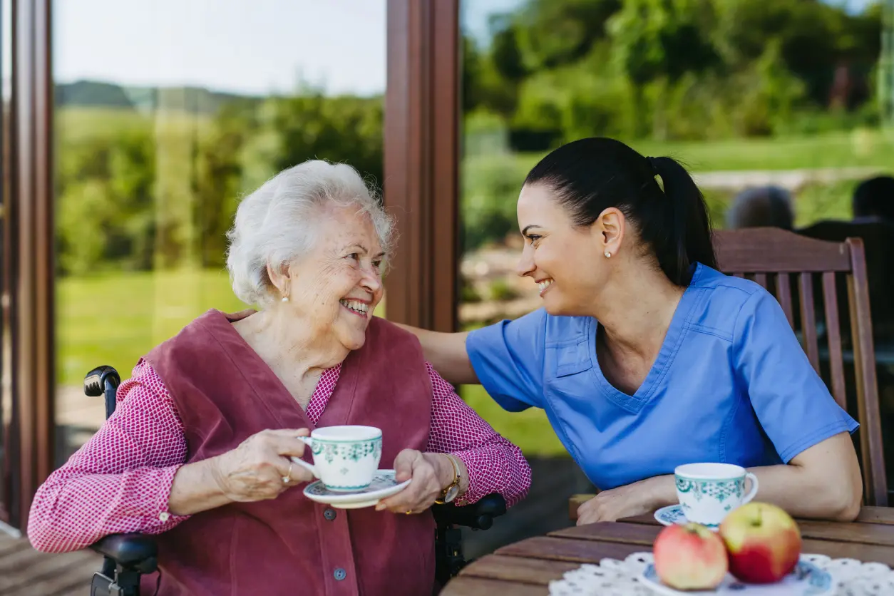 New Project(3) Elderly woman and caregiver enjoying tea outside.
